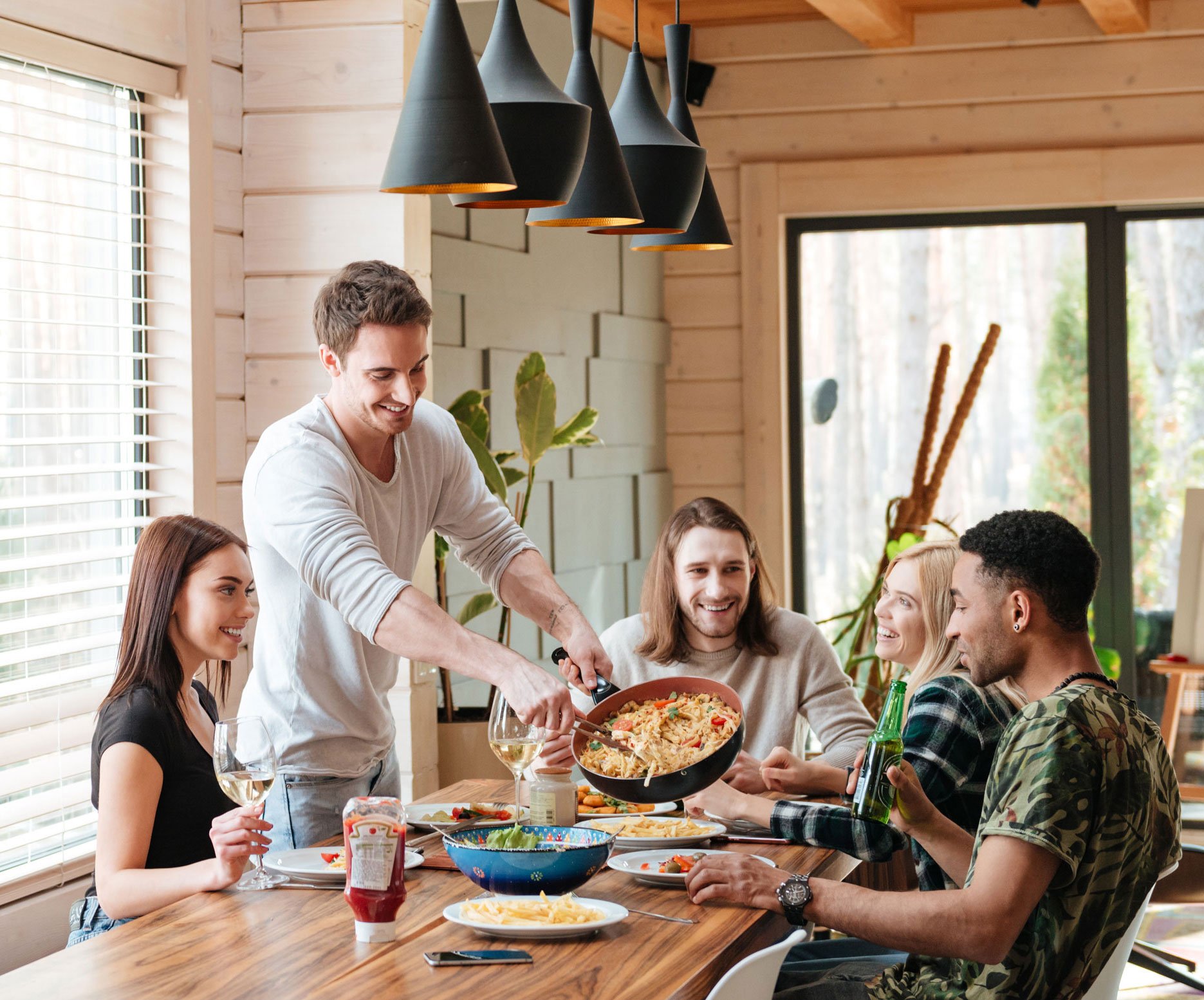 cheerful-young-people-eating-pasta-and-talking-on--P4NCA35